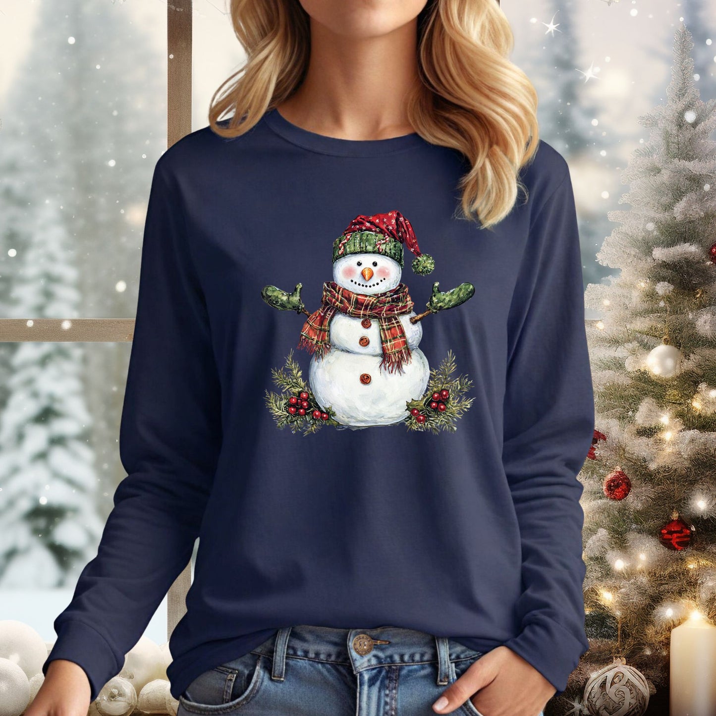 Navy long sleeve tee with a watercolor snowman wearing a plaid hat, scarf, green gloves, and holly.