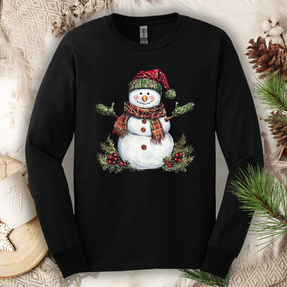 Black long sleeve tee with a watercolor snowman wearing a plaid hat, scarf, green gloves, and holly.