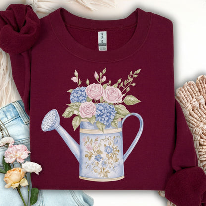 Maroon unisex sweatshirt with a watercolor watering can blooming with pastel roses and hydrangeas.