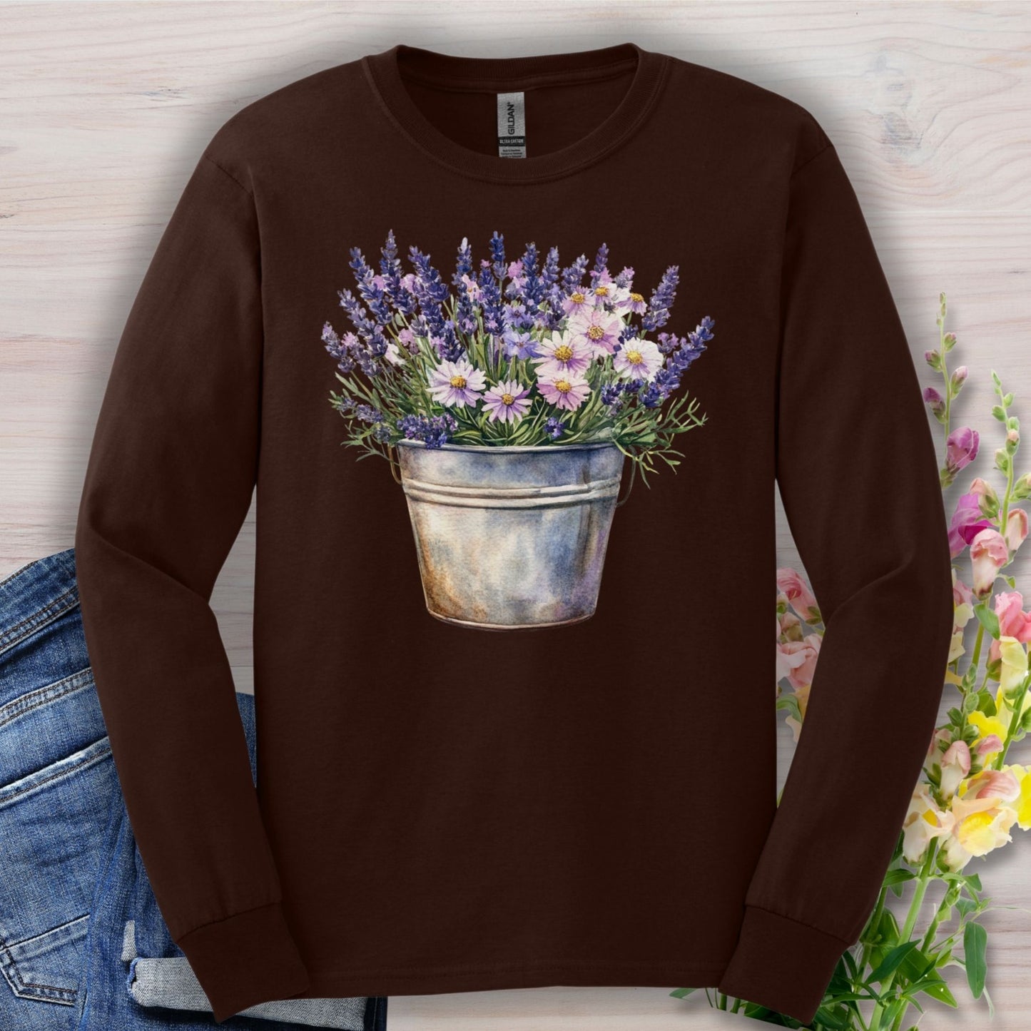 Dark chocolate long-sleeve tee with a hand-painted lavender and daisy bouquet in a weathered metal pail.