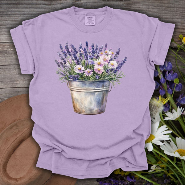 Orchid S garment-dyed t-shirt with a watercolor print of lavender and daisies in a weathered metal bucket.