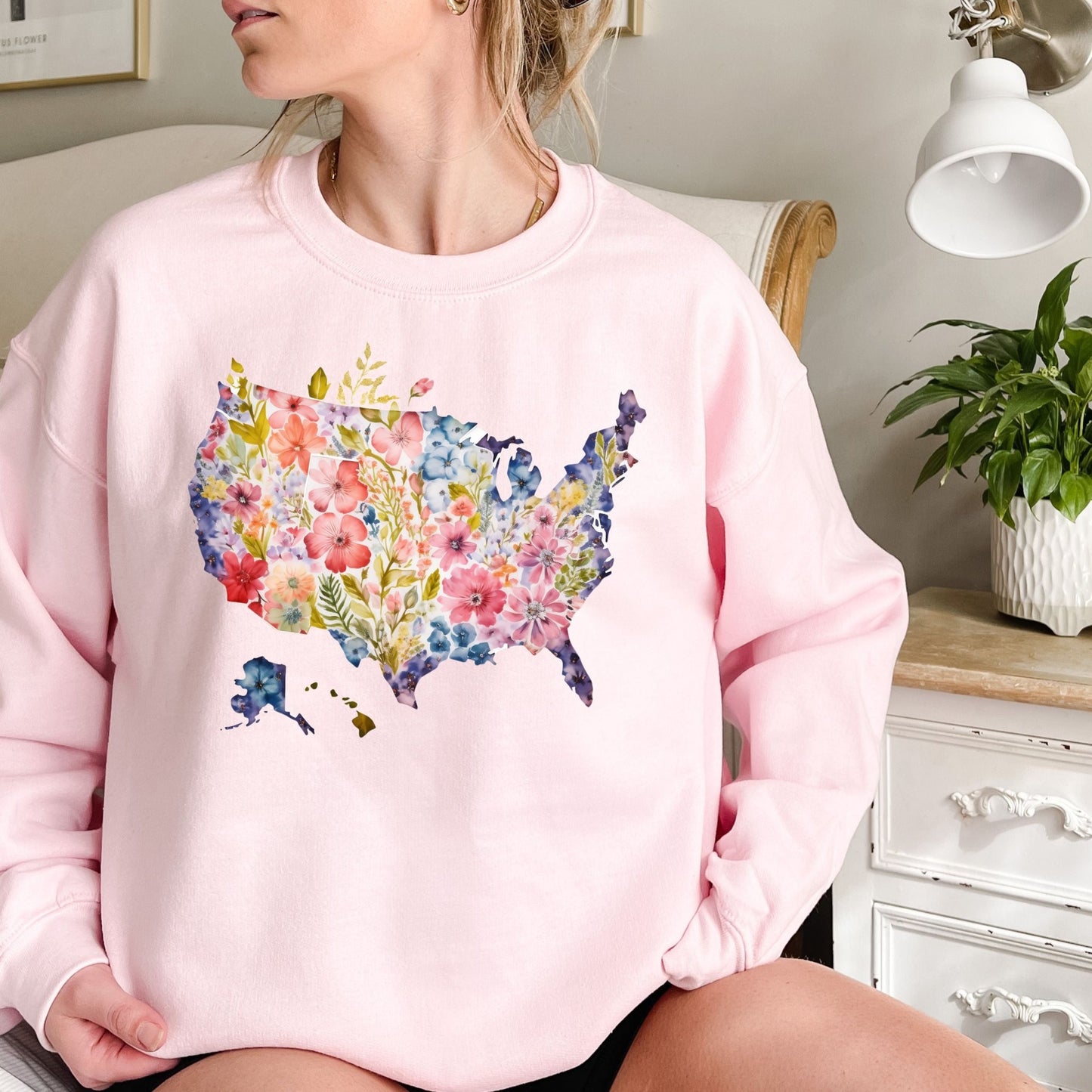Pink crewneck sweatshirt with a watercolor floral USA map design.