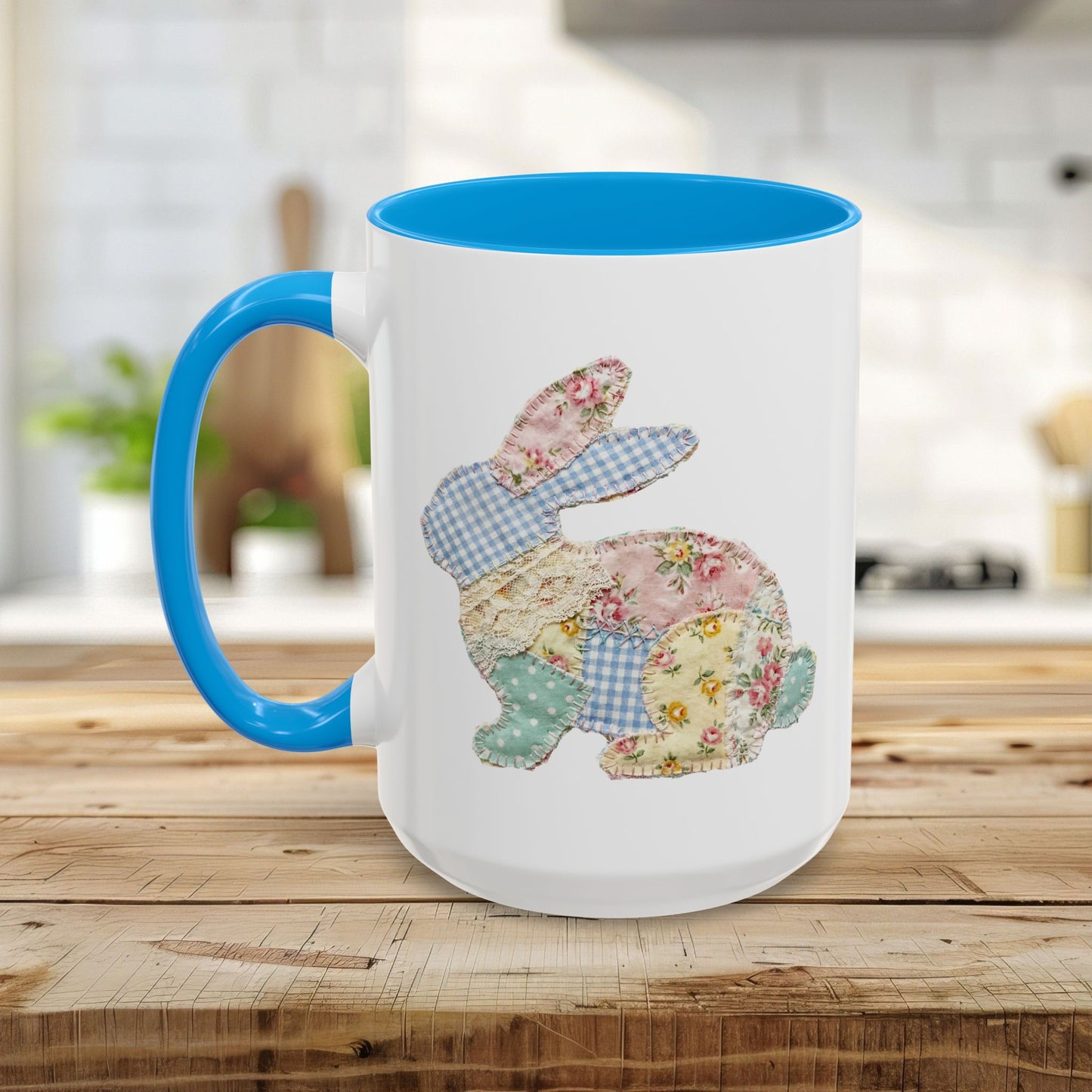 White ceramic mug with blue handle and interior, featuring a patchwork floral Easter bunny design.