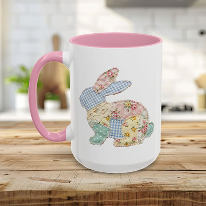 White ceramic mug with pink handle and interior, featuring a patchwork floral Easter bunny design.