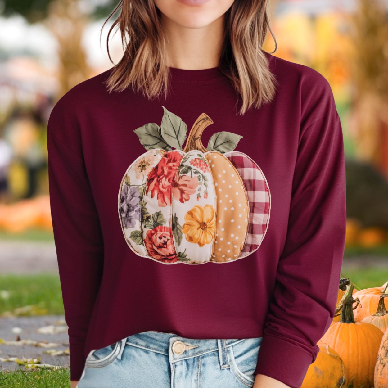 Maroon long sleeve tee with a faux patchwork pumpkin design featuring floral, gingham, and dotted patterns.