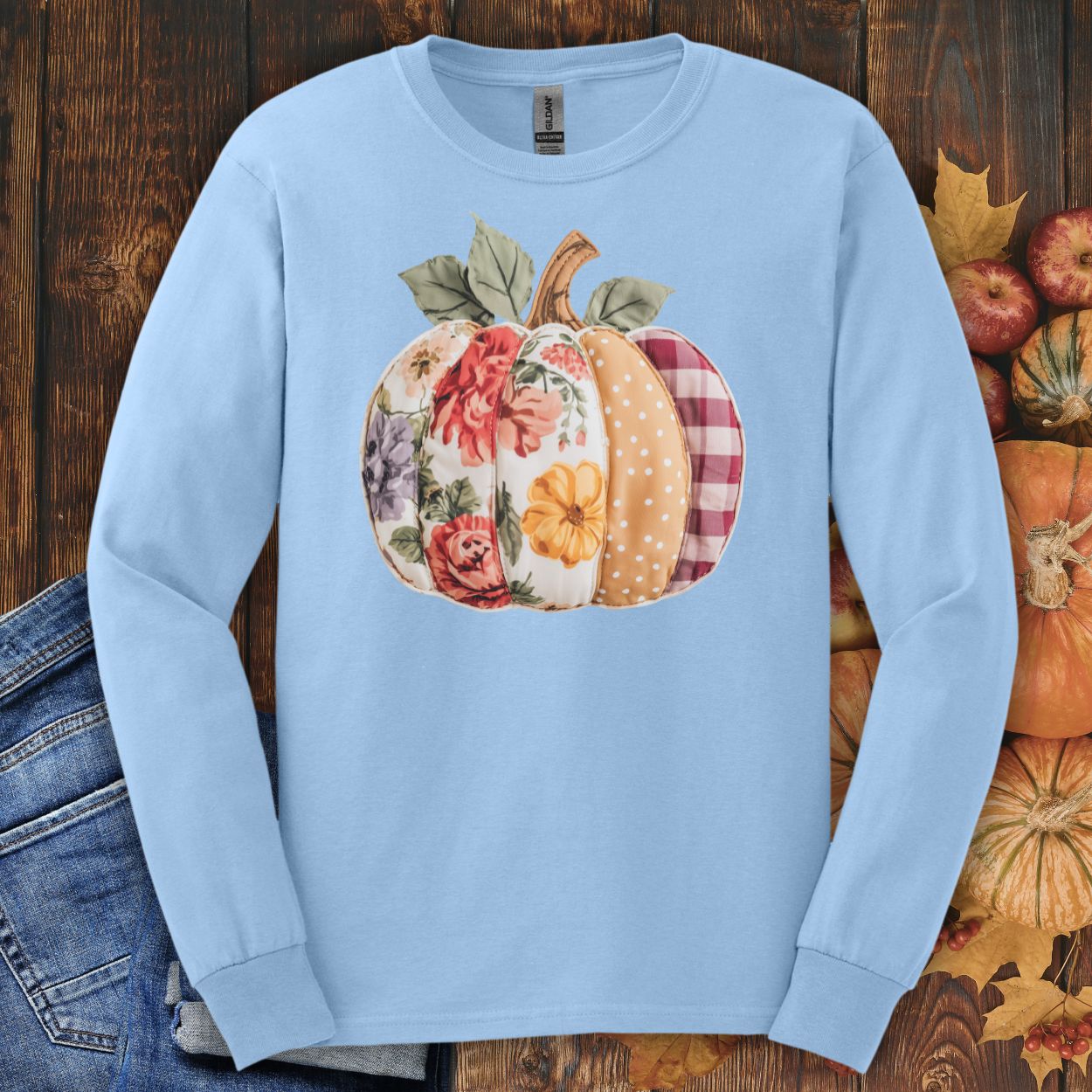 Light blue long sleeve tee with a faux patchwork pumpkin featuring floral, gingham, and dotted patterns.