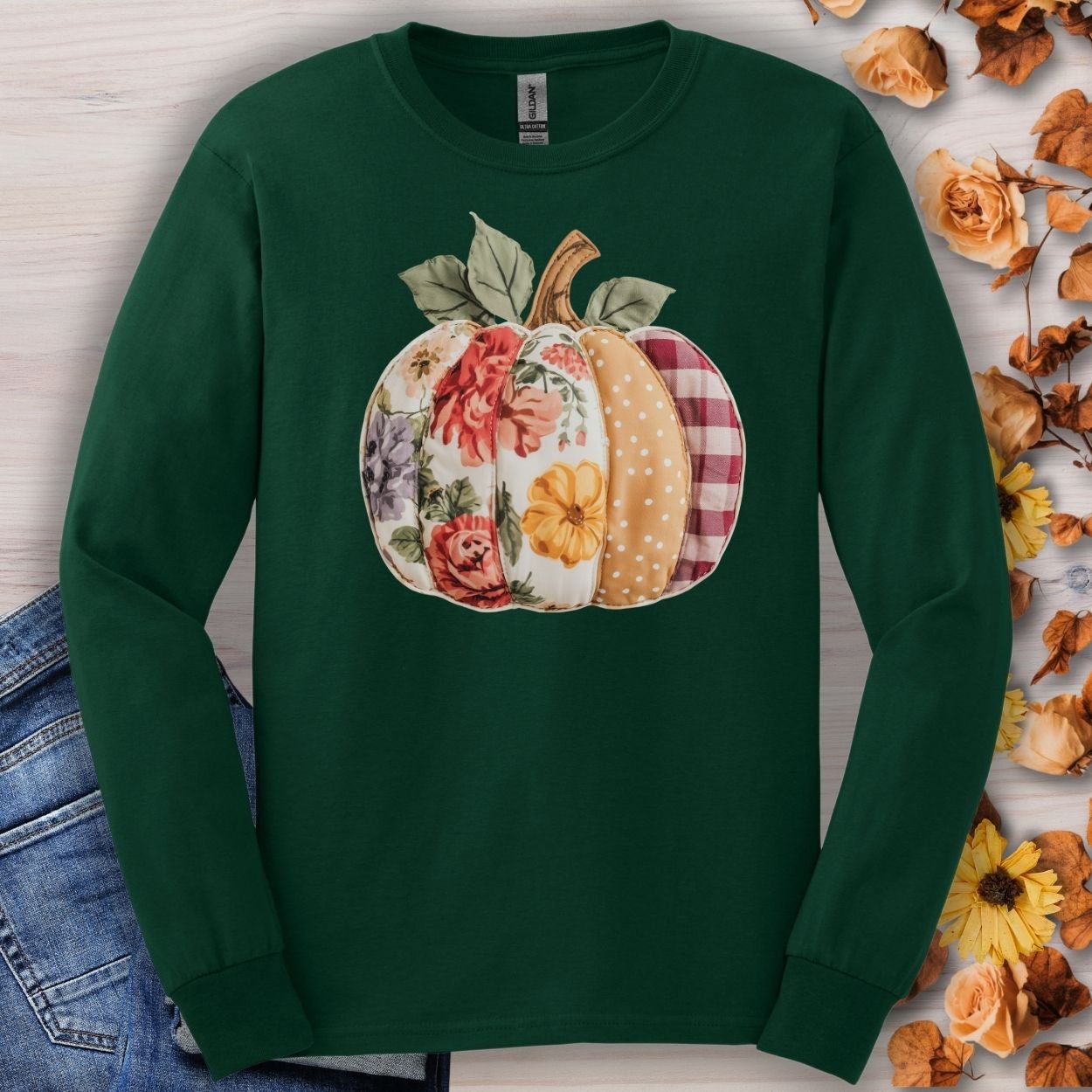 Forest green long sleeve tee with a faux patchwork pumpkin design featuring floral, plaid, and dotted patterns.