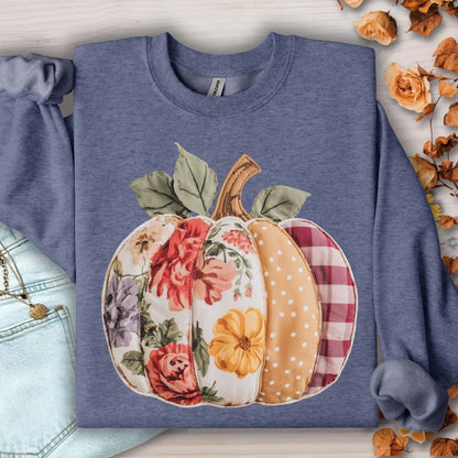 Heathered blue crewneck sweatshirt with a faux patchwork pumpkin design featuring floral, gingham, and polka dot patterns.