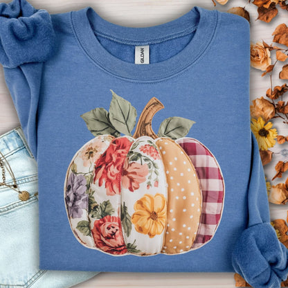 Indigo blue sweatshirt with a faux patchwork pumpkin design featuring floral, gingham, and polka dot patterns.