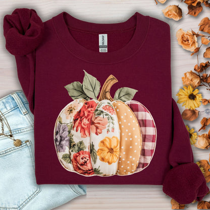 Maroon crewneck sweatshirt with a faux patchwork pumpkin design featuring floral, polka dot, and plaid patterns.