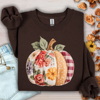 Dark chocolate crewneck sweatshirt with a faux patchwork pumpkin design featuring floral, gingham, and polka dot patterns.