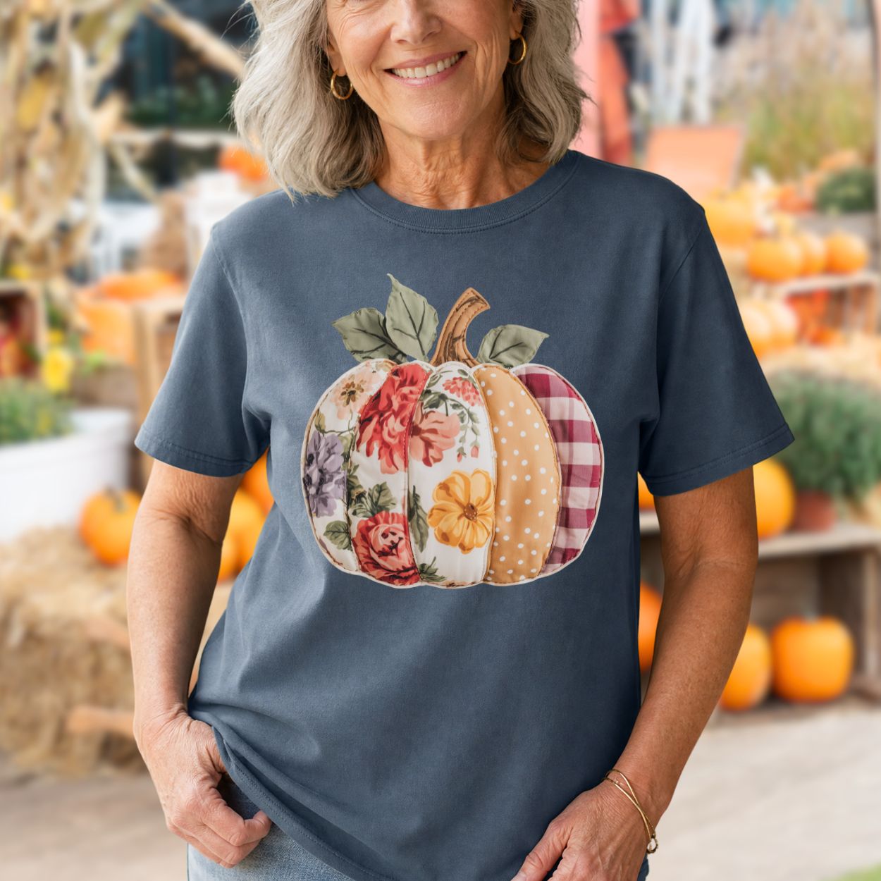Woman in a Comfort Colors blue tee with a floral & plaid faux patchwork pumpkin design.