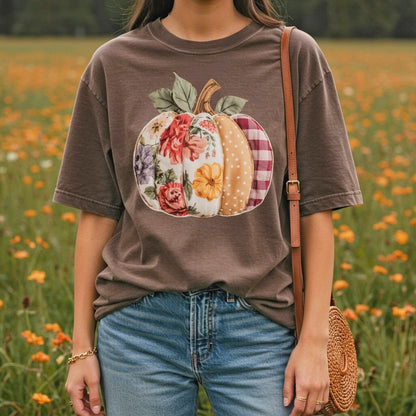 Comfort Colors tee with a floral & plaid patchwork pumpkin design, worn by a person in a field.