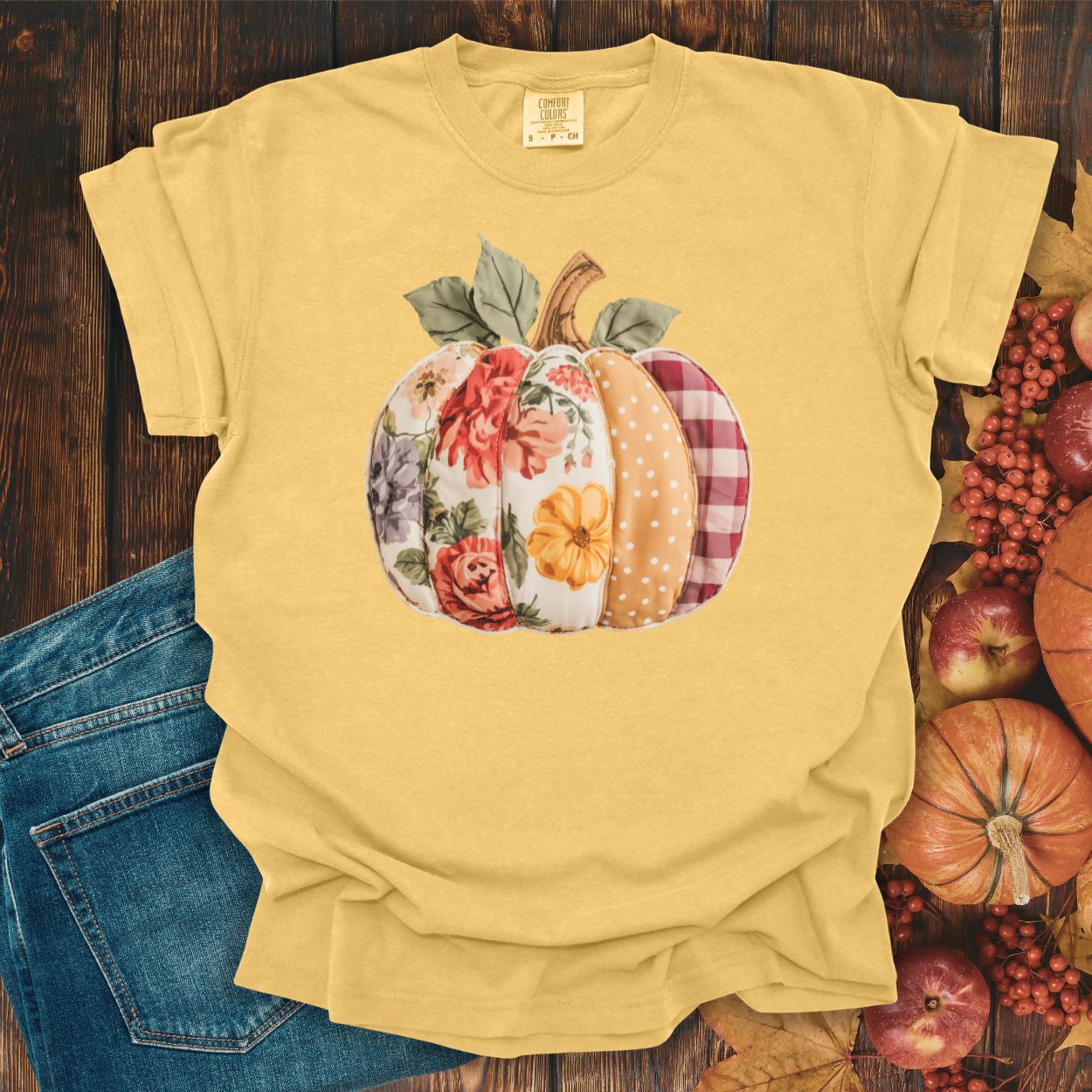 Yellow Comfort Colors tee with a faux patchwork pumpkin design featuring florals, plaid, and polka dots.