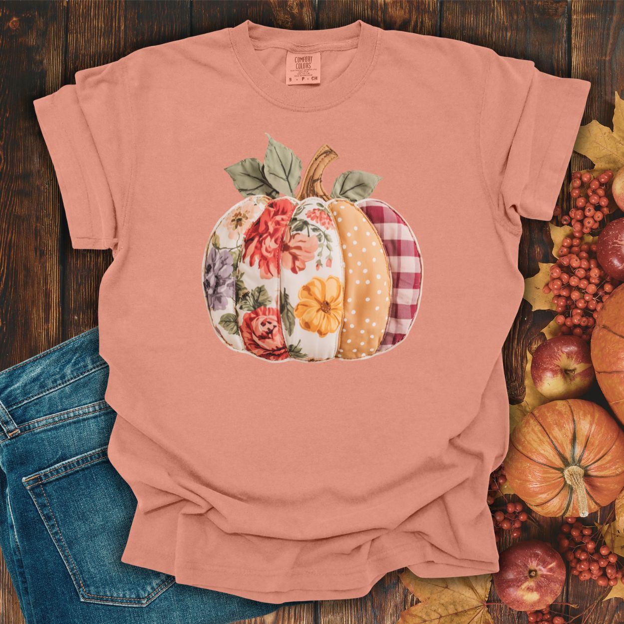 Terracotta Comfort Colors t-shirt with a faux patchwork pumpkin design featuring floral, gingham, and polka dot patterns.
