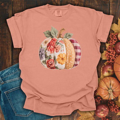Terracotta Comfort Colors t-shirt with a faux patchwork pumpkin design featuring floral, gingham, and polka dot patterns.