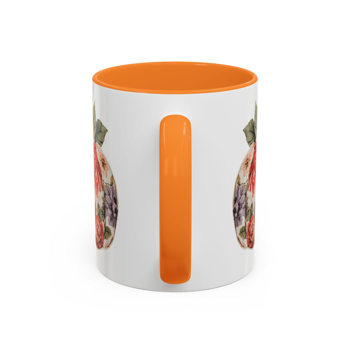 White ceramic mug with orange handle and interior, featuring a colorful floral and plaid patchwork pumpkin design.