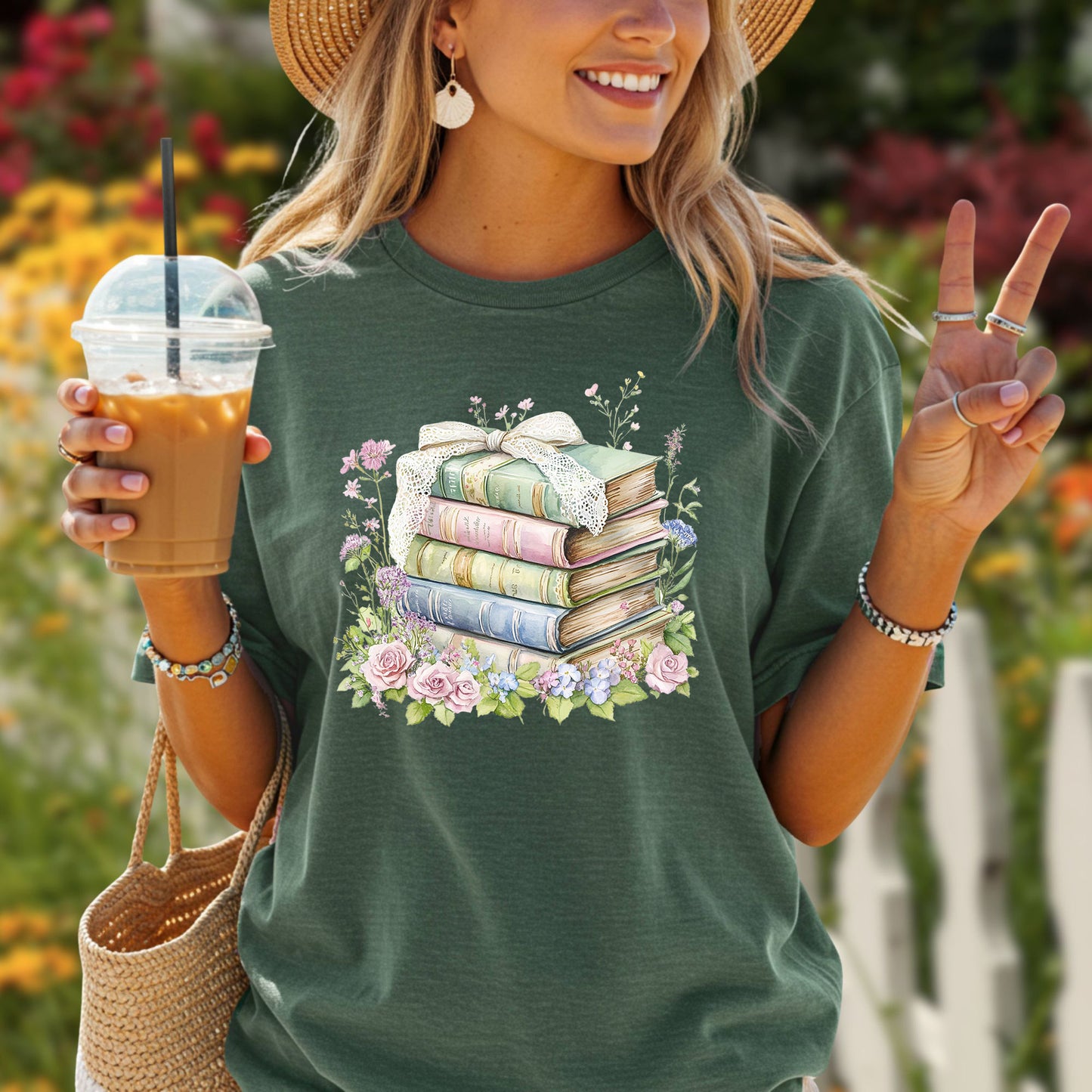 Woman in a green t-shirt with a stack of vintage books tied with lace ribbon and surrounded by watercolor flowers.