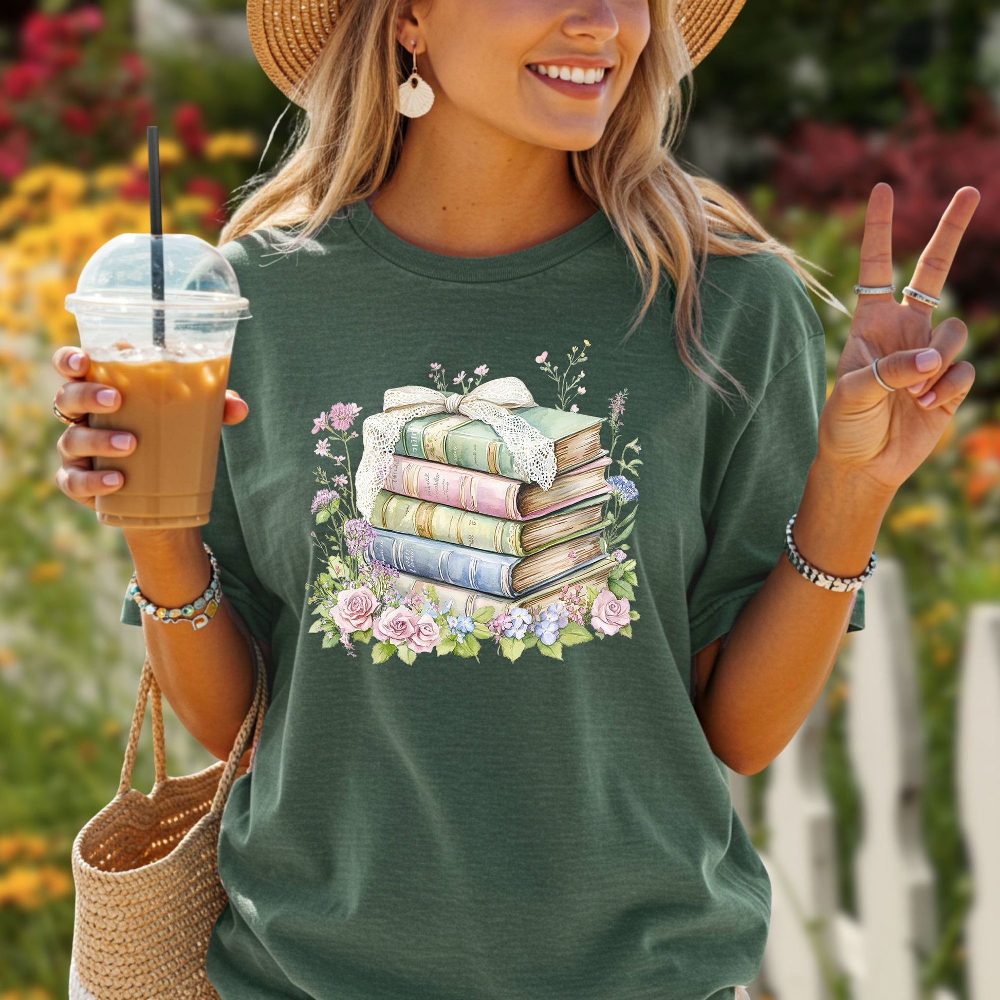 Woman in a green t-shirt with a stack of vintage books tied with lace ribbon and surrounded by watercolor flowers.