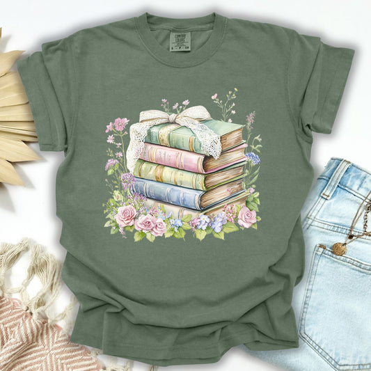 Moss green t-shirt with a watercolor floral stack of vintage books design, tied with a lace ribbon.