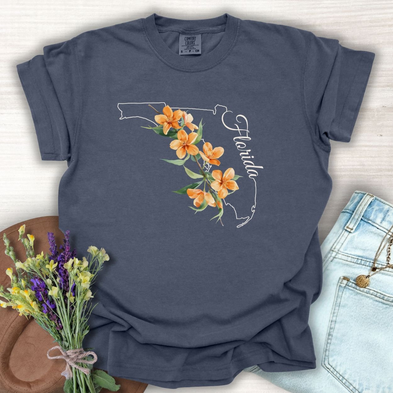 Denim S t-shirt with a white Florida state outline, orange blossoms, and "Florida" script.