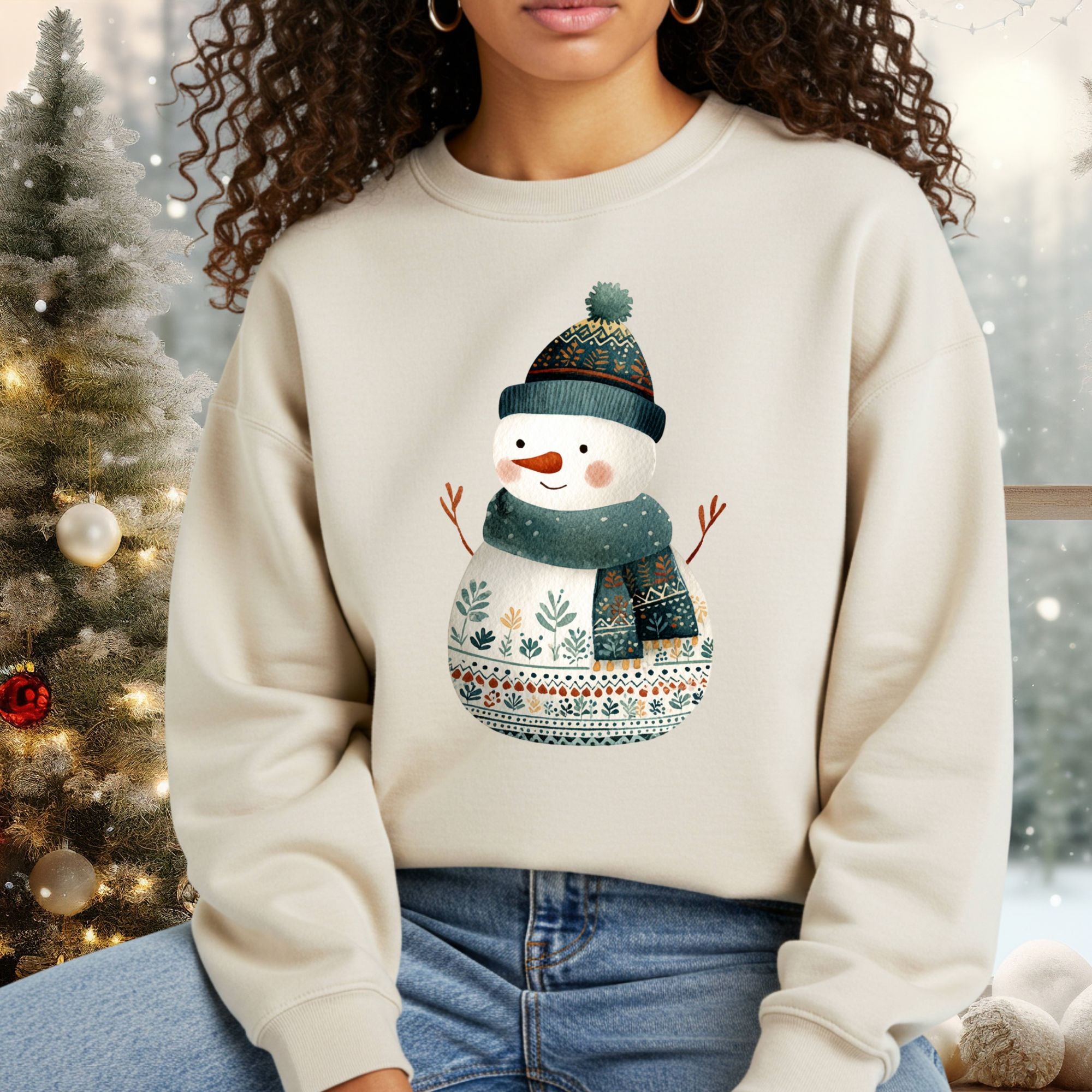 Gildan crewneck sweatshirt with a folk art snowman in a teal hat and scarf, surrounded by winter decor.