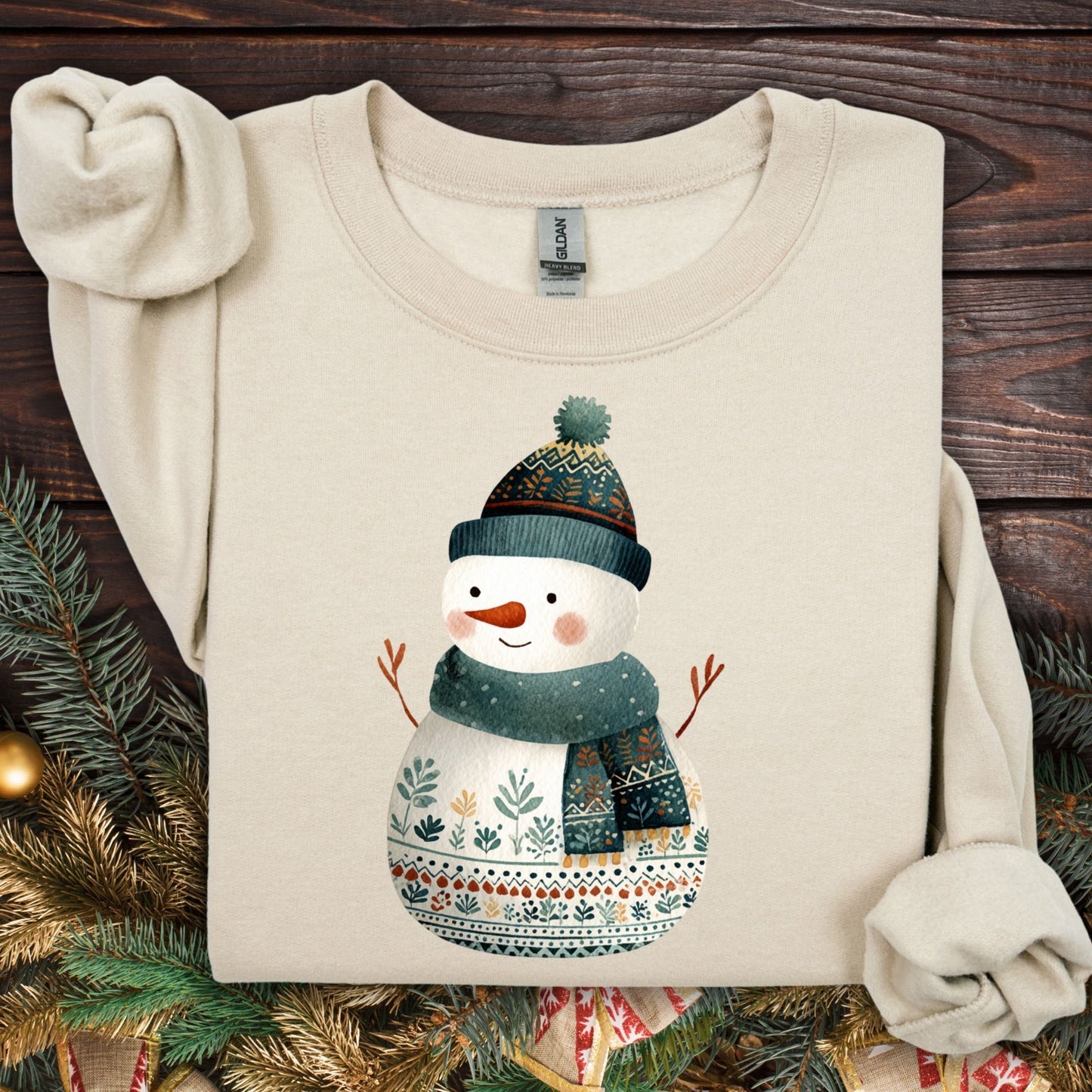 Sand Gildan crewneck sweatshirt with a folk art snowman in a teal hat and scarf.