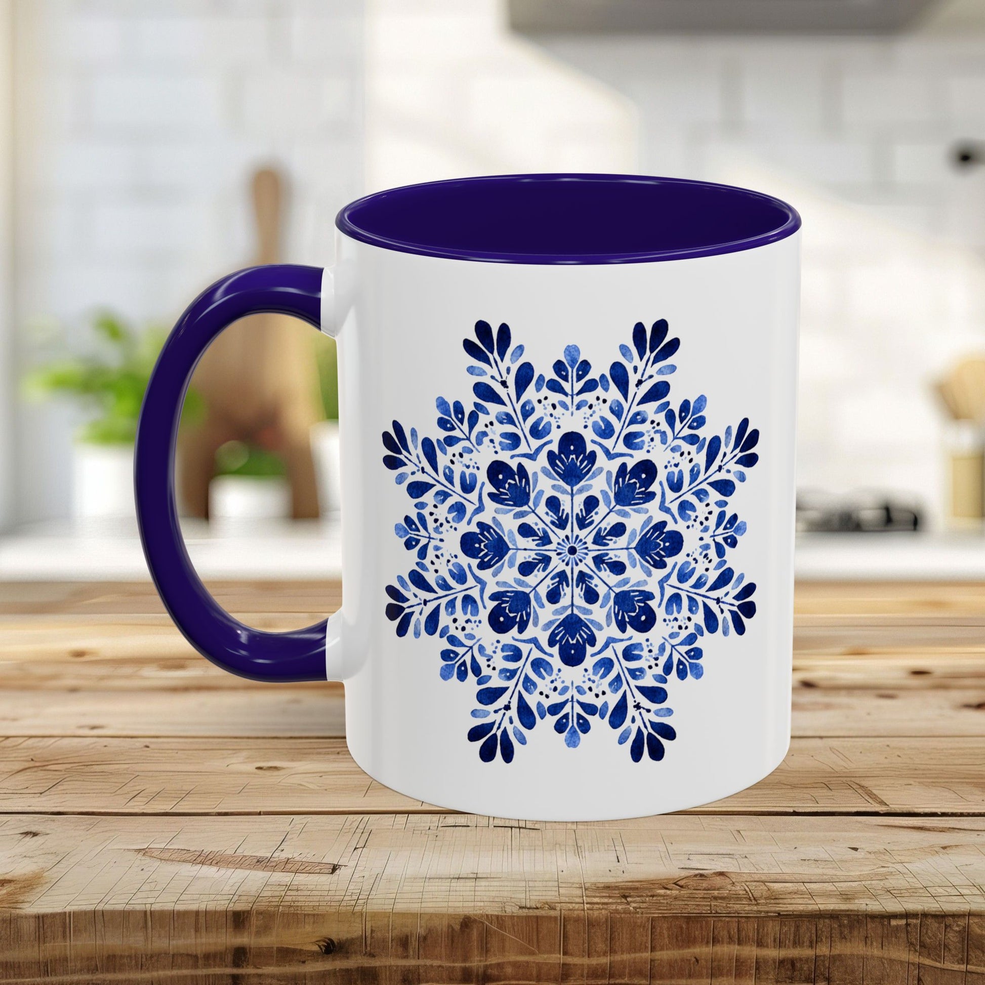 White ceramic mug with a vibrant blue floral snowflake design and a contrasting purple interior and handle.