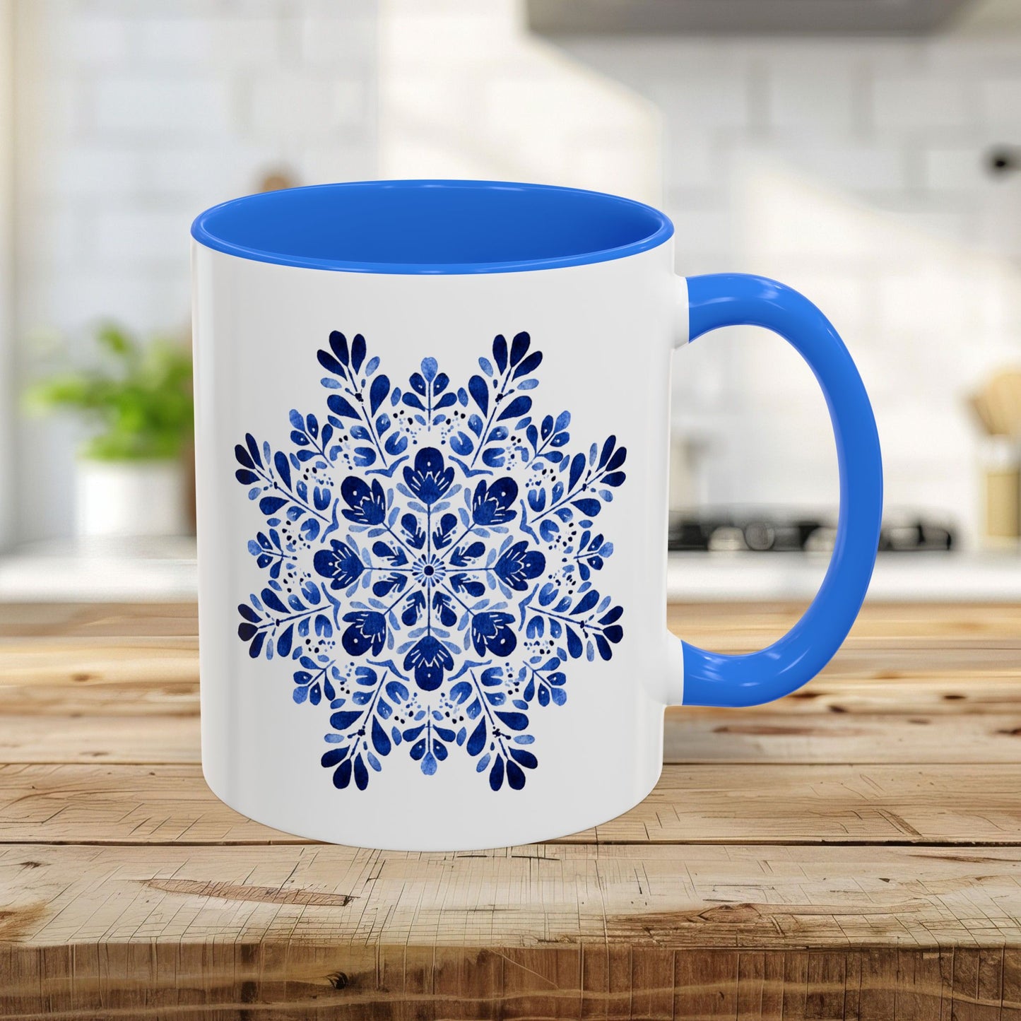 White 11oz ceramic mug with Cambridge Blue interior/handle and a detailed blue floral snowflake design.