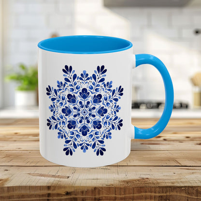 11oz white ceramic mug with light blue interior/handle and a detailed blue floral snowflake design.