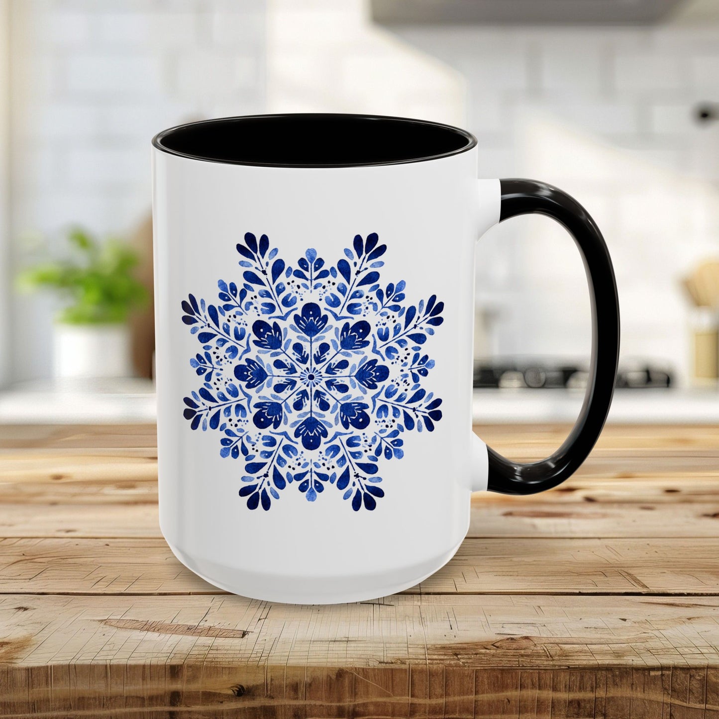 15oz white ceramic mug with a black interior and handle, featuring a detailed blue floral snowflake mandala.