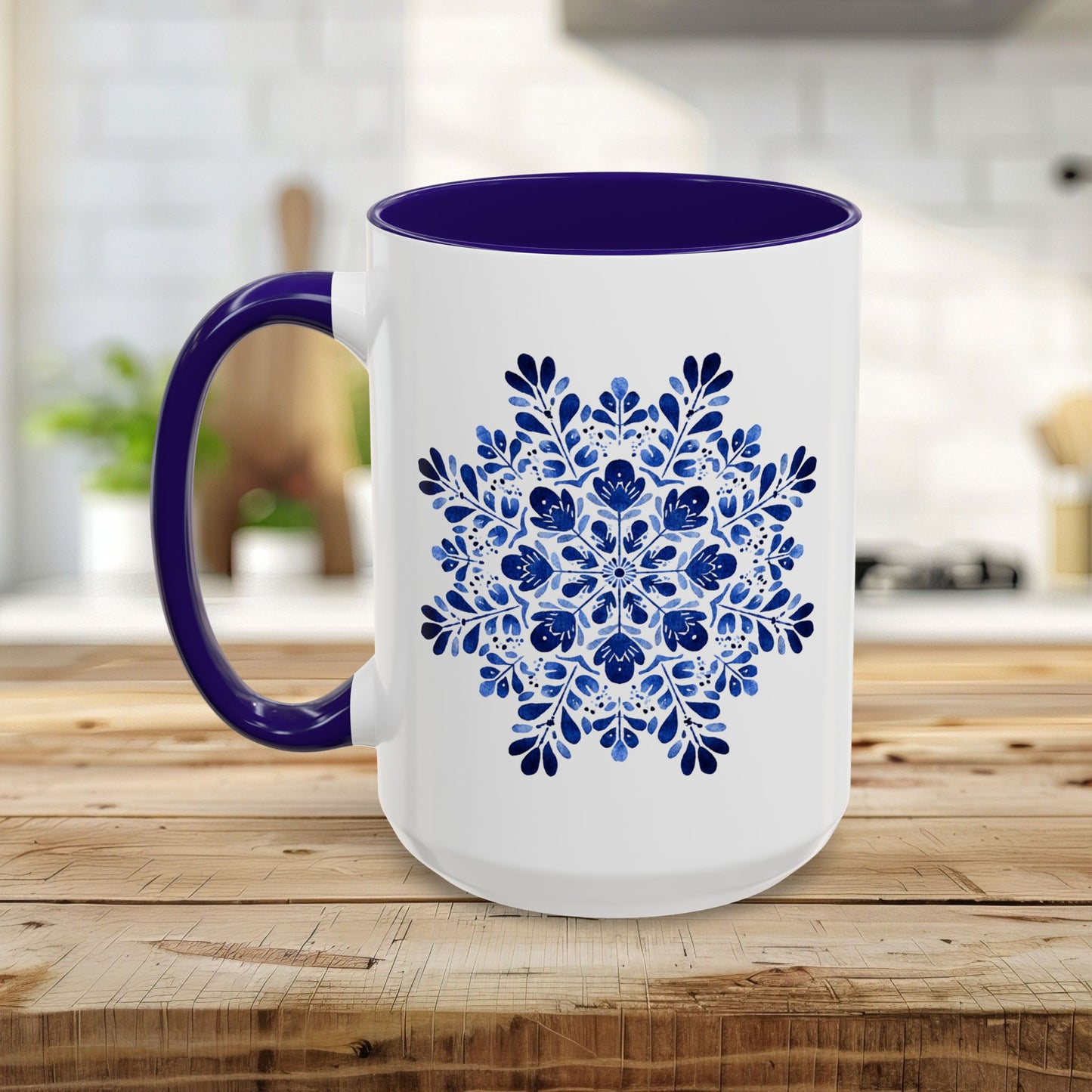 White ceramic mug with a vibrant blue floral snowflake design, purple interior, and C-shaped handle.