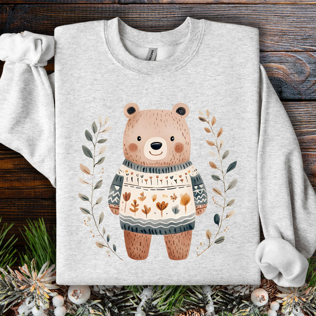 Ash S sweatshirt with a cute folk art bear in a botanical sweater, framed by leaves.