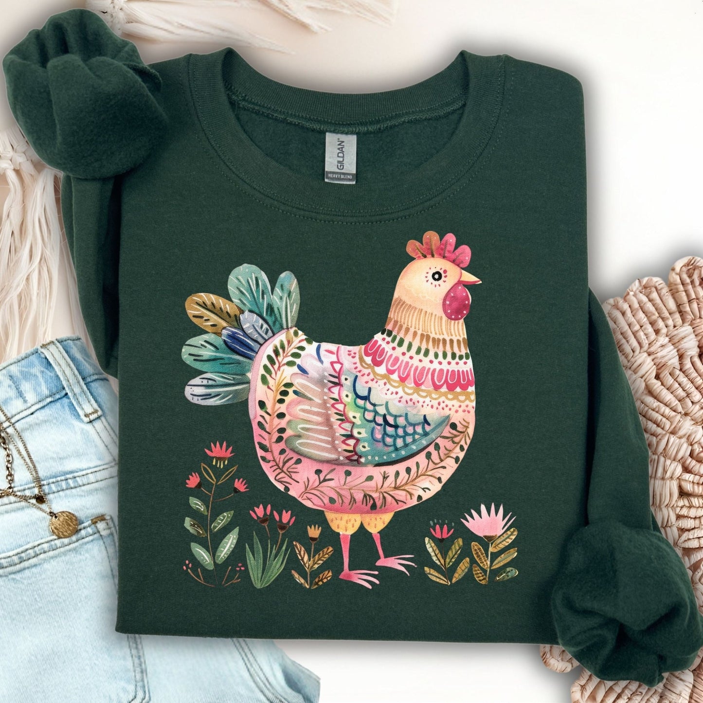 Forest green crewneck sweatshirt with a whimsical folk art chicken print in muted pinks, teal, and florals.