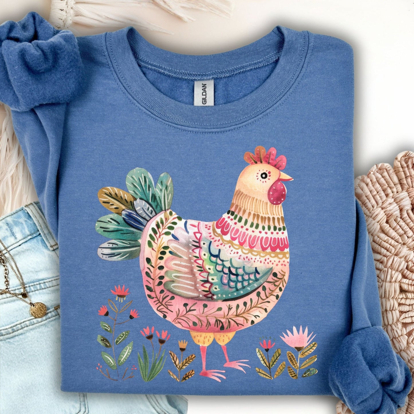 Indigo blue crewneck sweatshirt with a colorful folk art chicken and floral design.
