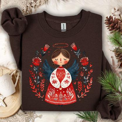 Dark Chocolate Gildan sweatshirt with a folk art Christmas angel in red, green, and navy, surrounded by pine.