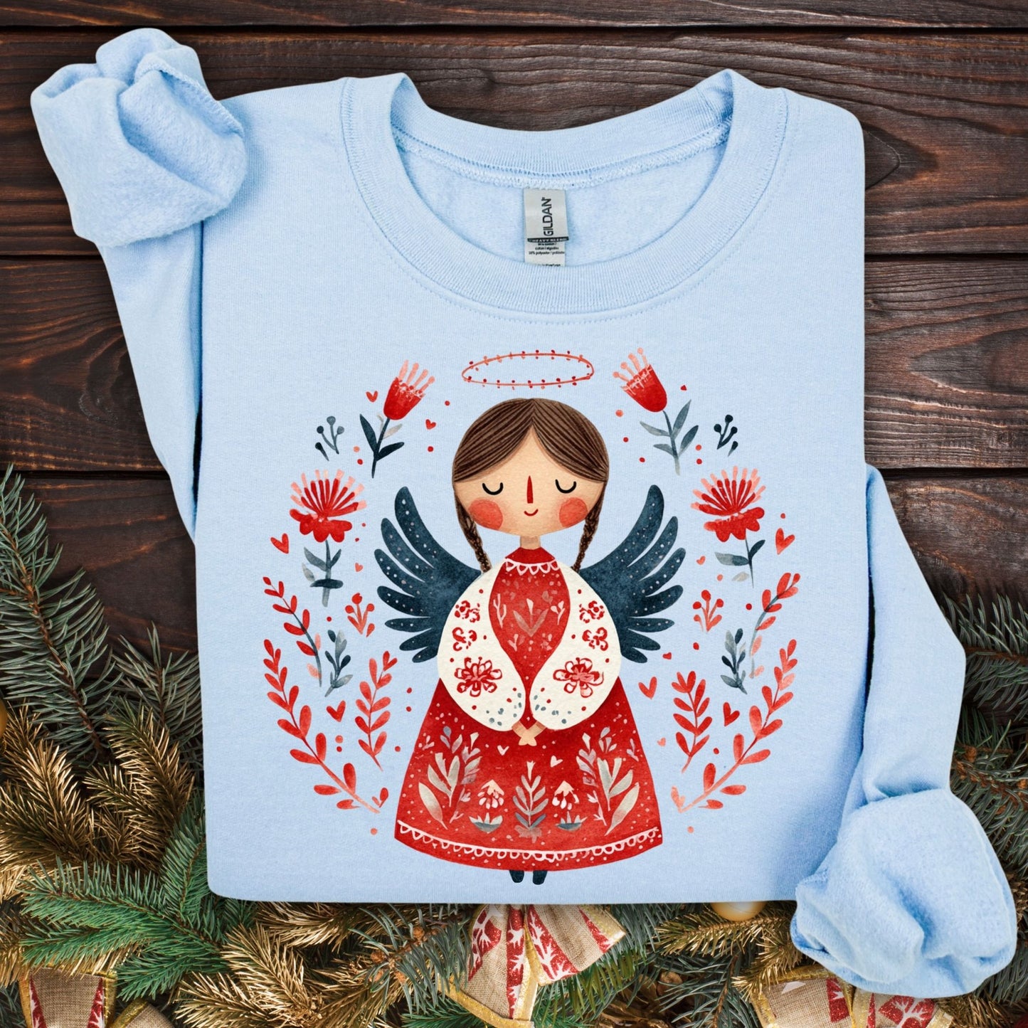 Light blue Gildan crewneck sweatshirt with a folk art Christmas angel in red, green, and navy.