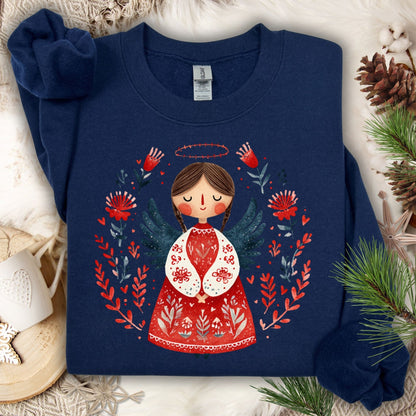 Navy Gildan crewneck sweatshirt with a folk art Christmas angel in red and green, surrounded by festive botanicals.