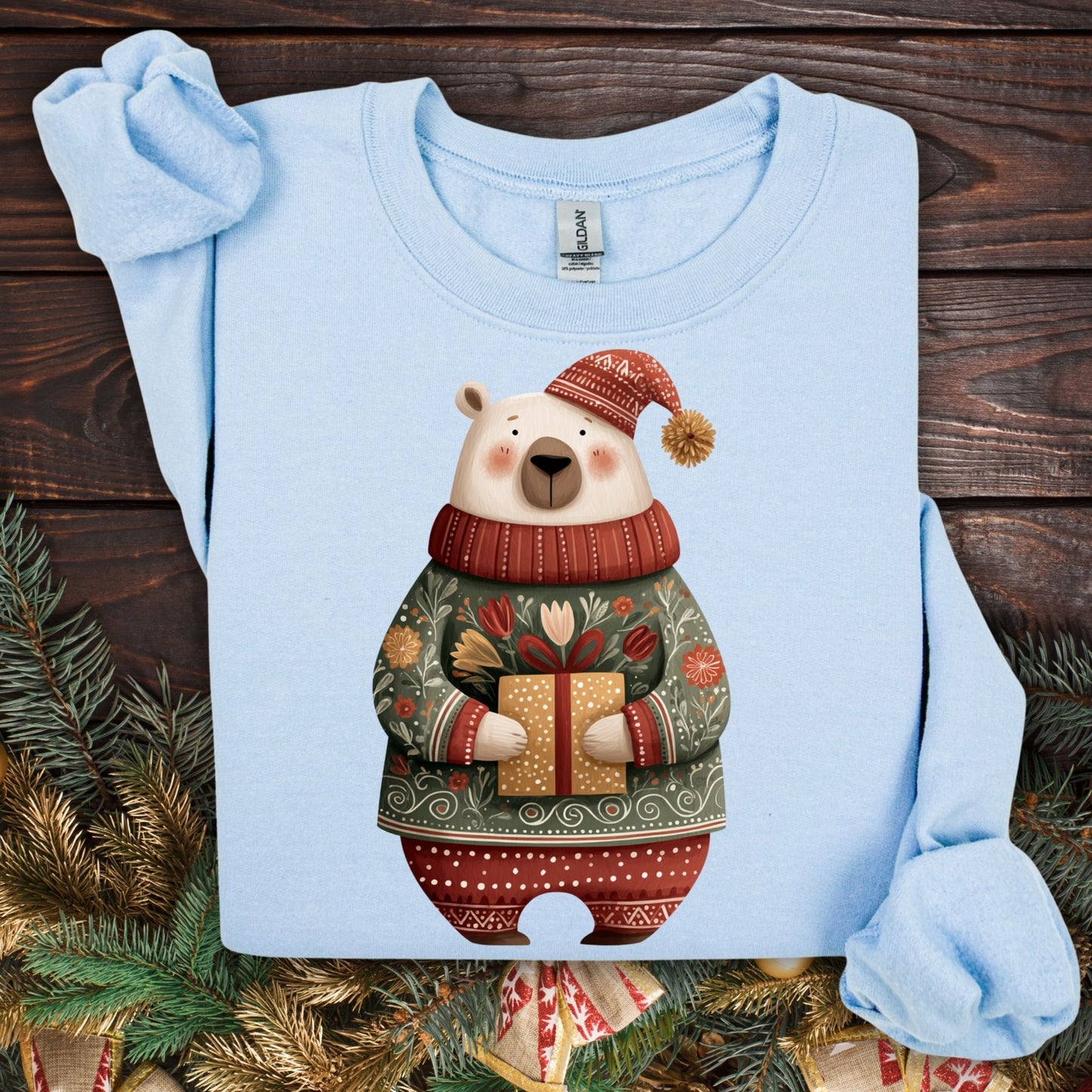 Light blue Gildan crewneck sweatshirt with a folk art polar bear in a fair isle sweater holding a gift.