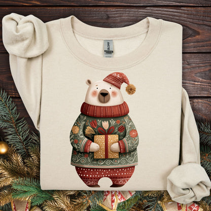 Sand Gildan crewneck sweatshirt with a folk art polar bear in a fair isle sweater, holding a gift.
