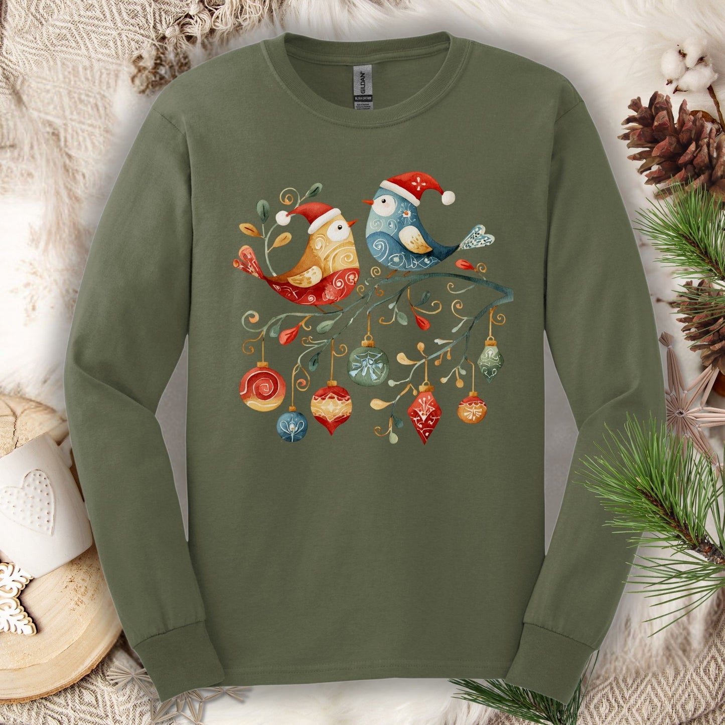Military green long sleeve tee with folk art sparrow and bluebird in Santa hats on a festive branch with ornaments.