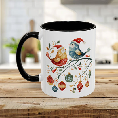 White ceramic mug with black handle and interior, featuring folk art Christmas birds and ornaments.
