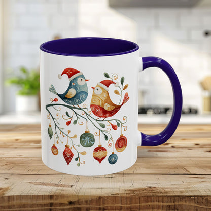 White 11oz ceramic mug with blue interior and handle, featuring two folk art Christmas birds on a festive branch.