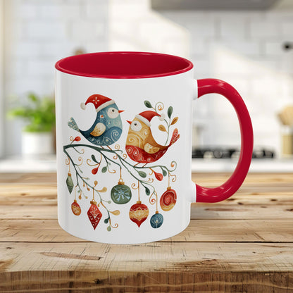 Glossy white ceramic mug with red handle and interior, featuring two folk art Christmas birds on a festive branch.