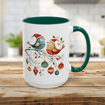 15oz white ceramic mug with green handle and interior, featuring two folk art Christmas birds on a festive branch.