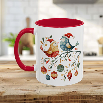 Glossy white ceramic mug with red interior and handle, featuring two folk art Christmas birds and ornaments.