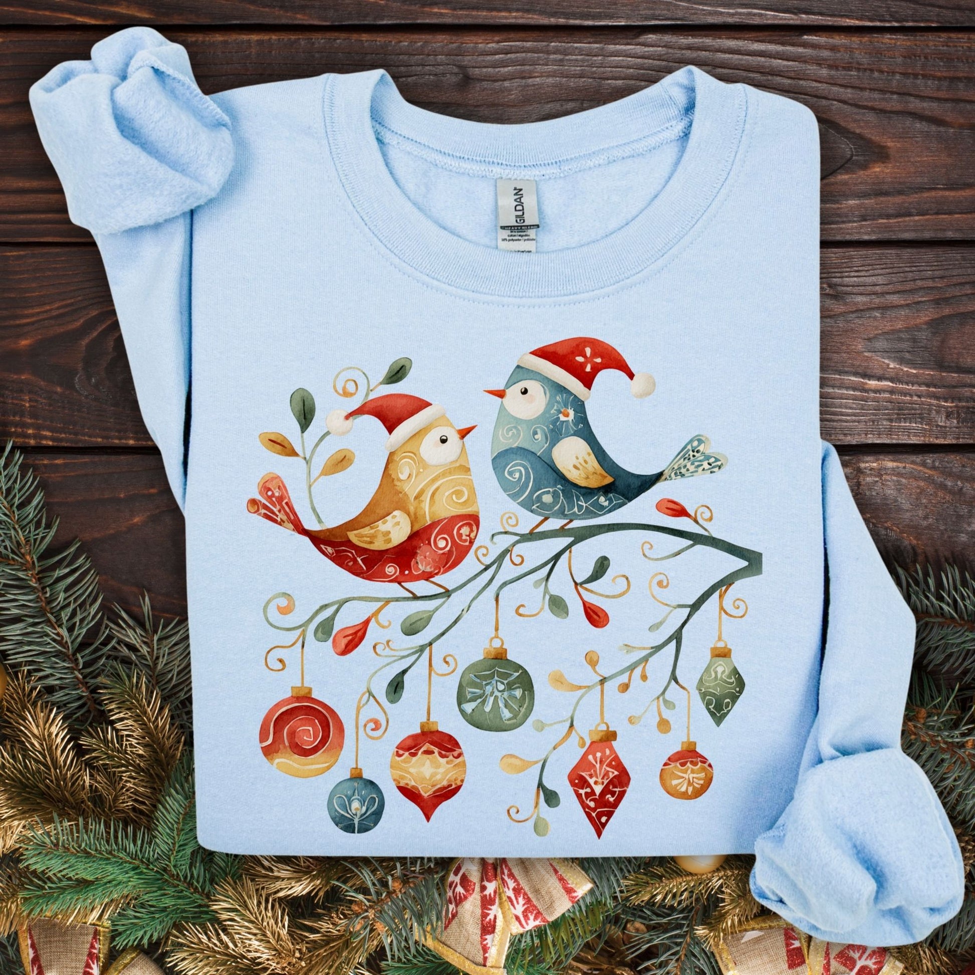 Light blue Gildan sweatshirt with folk art Christmas birds and ornaments design.
