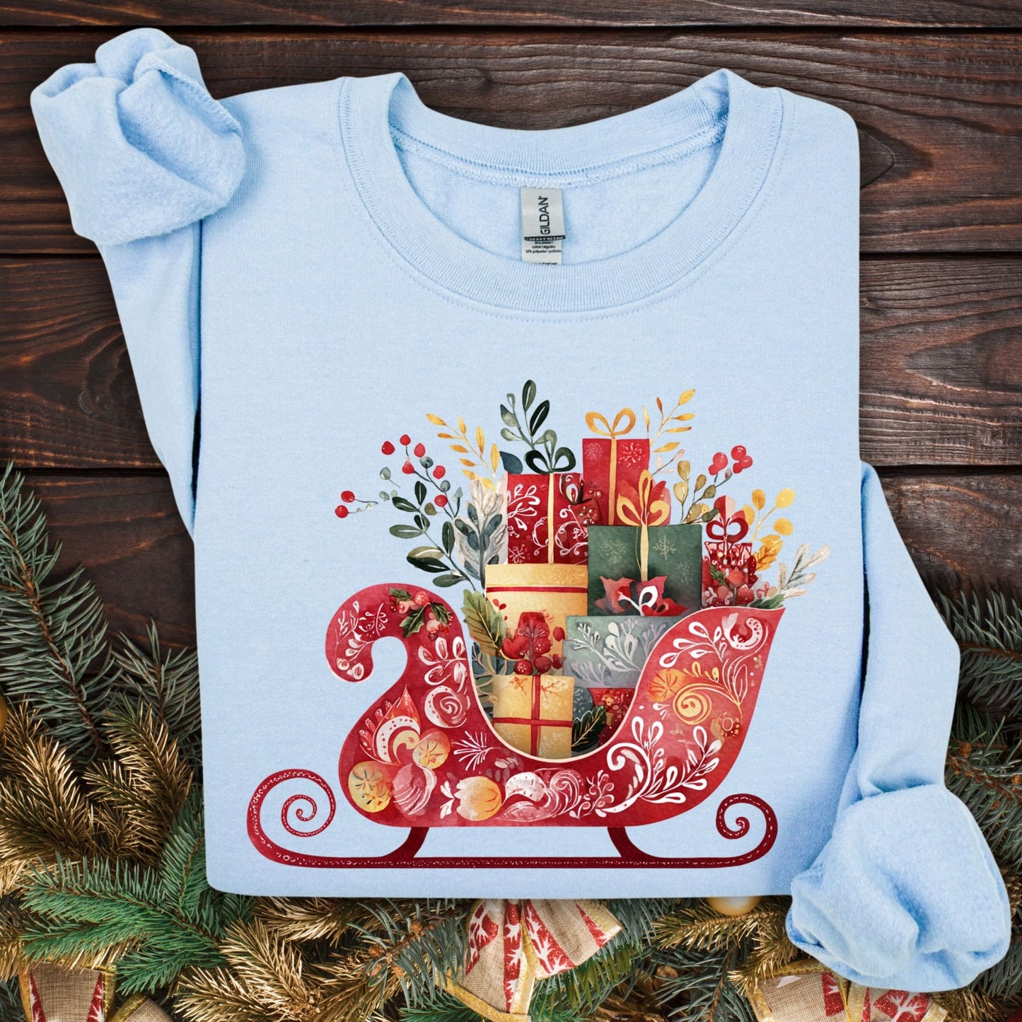 Light blue Gildan crewneck sweatshirt with folk art red sleigh brimming with colorful Christmas gifts.
