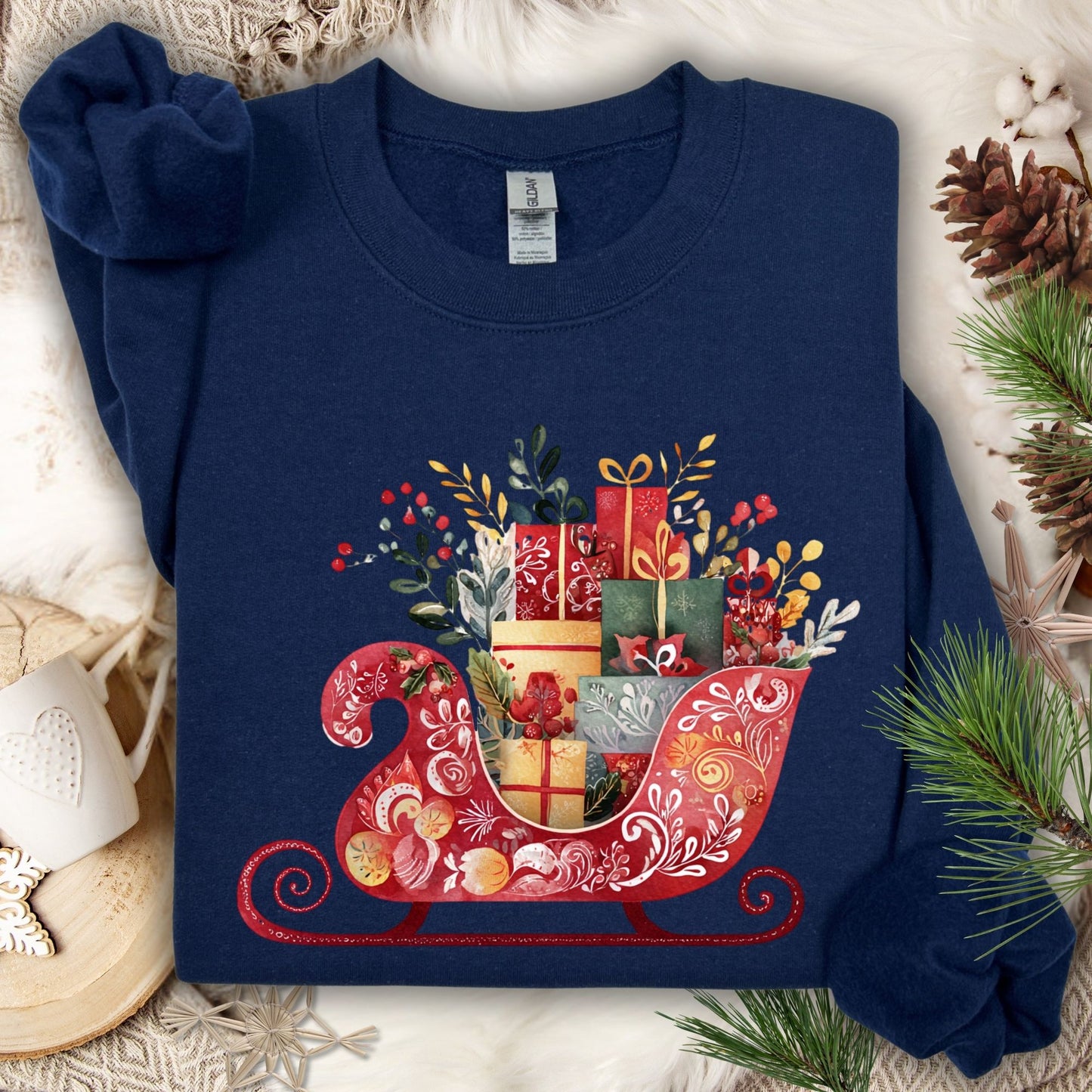 Navy Gildan crewneck sweatshirt with folk art Christmas sleigh brimming with gifts in red, gold, green, and blue.