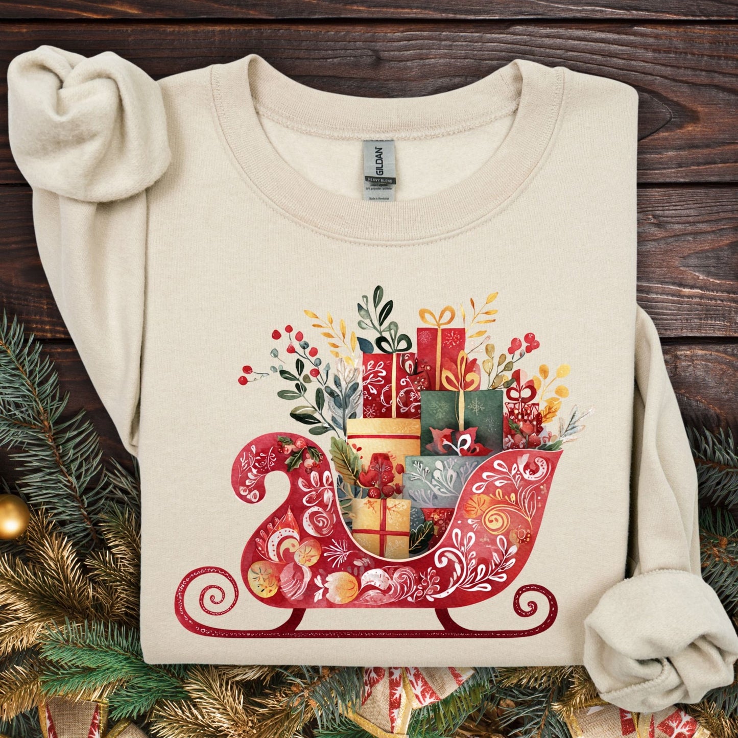 Sand Gildan crewneck sweatshirt with a folk art Christmas sleigh brimming with gifts.
